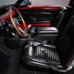 Full interior overview of the 1967 Ford Mustang Fastback 501 Pro-Touring showing the fully restored black vinyl upholstery, Hurst V-Matic2 T-shifter, custom JME Autometer dash gauges, and 14-inch wood grain steering wheel