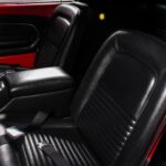 Driver's seat of the 1967 Ford Mustang Fastback 501 Pro-Touring in fully restored black vinyl upholstery with front lap belt, part of the meticulously restored black interior