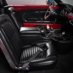 Full passenger side interior overview of the 1967 Ford Mustang Fastback 501 Pro-Touring showing the fully restored black vinyl upholstery, Hurst V-Matic2 T-shifter, custom JME Autometer dash gauges, and 14-inch wood grain steering wheel
